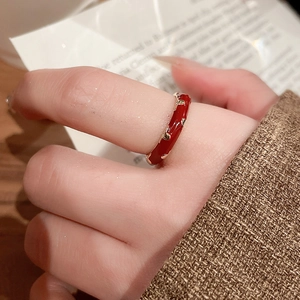 Close-up of red enamel 14k gold plated ring with leaf details worn on the finger
