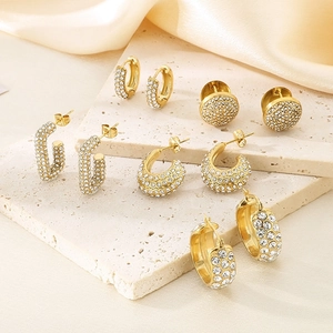 Détails de cinq styles de boucles d'oreilles en acier doré ornées de cristaux brillants
