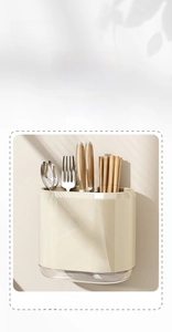 Detail view of wall-mounted kitchen utensil holder with transparent drain tray in cream white