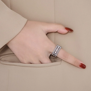 Detail of silver multi-layer gear ring with zircon inlay worn by model on suit pocket