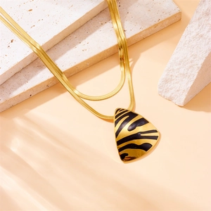 Double-layer gold snake chain necklace with triangular tiger print pendant on stone