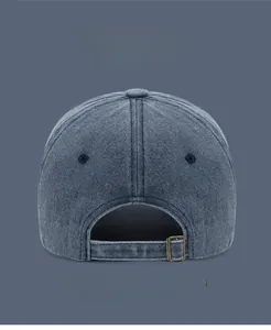 Close-up of vintage washed denim baseball cap with adjustable brass metal buckle closure