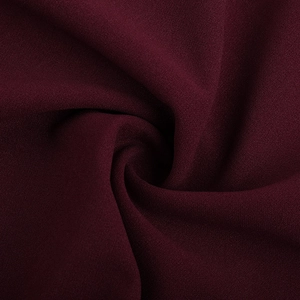 Vue détaillée du tissu mousseline bordeaux avec d'élégants motifs de plis en spirale