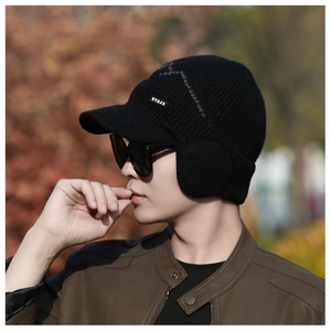 Close-up of black knitted men's winter hat with warm earflaps and a protective brim