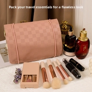 Close-up of pink checkered vanity case with makeup brushes and elegant cosmetic accessories