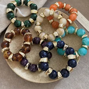 Set of colorful acrylic round bead bracelets with marble texture and golden spacers