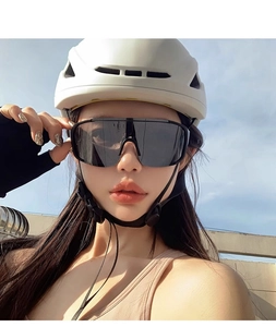 Outdoor sport sunglasses with black oversized frame worn with cycling helmet for protection