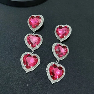 Macro shot of silver drop earrings with triple pink heart crystals and micro-pave diamonds