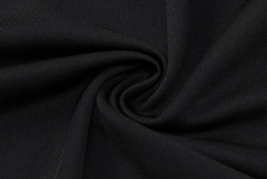 Macro shot showing the fine texture and high elasticity of black knitted yoga fabric