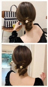 Detail of minimalist hair tie with a gold metal ball on a stylish low bun hairstyle