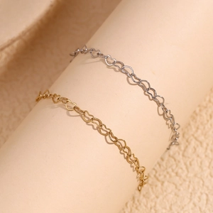 Close-up of gold and silver heart-shaped link chains wrapped on a cylinder pedestal