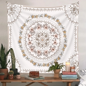 Bohemian mandala tapestry with floral patterns hanging over a wooden console with plants
