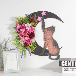 Detail of crescent moon cat wall decor featuring colorful flowers and pink stars