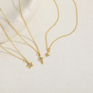 Three gold dainty necklaces with sparkling star pendants in a layered minimalist style