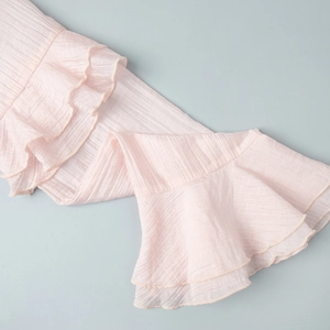 Close-up of pink pleated fabric with delicate ruffle details and fine craftsmanship