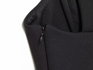 Détail de la fermeture éclair invisible sur le tissu noir de la robe courte