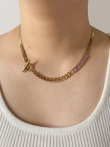 Detail of gold snake chain necklace with pink zircon accents and OT toggle clasp