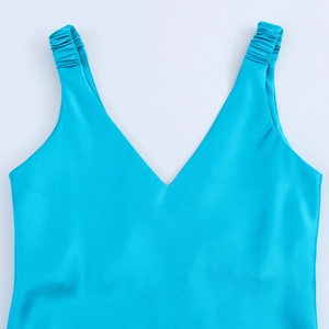 Detail view of teal satin V-neck dress with ruched shoulder straps and silk texture