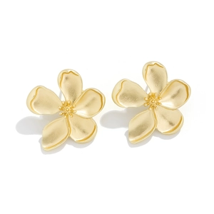 Close-up of elegant matte gold five-petal flower earrings with textured 3D floral details