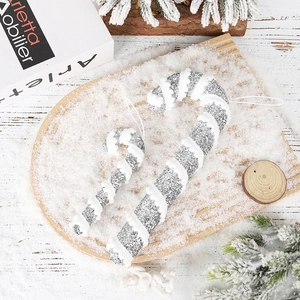Close-up of glittery silver candy cane Christmas ornaments with white snowflake swirls