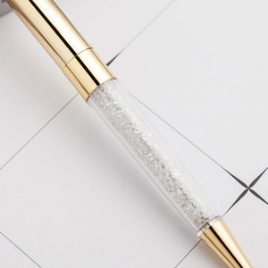 Elegant gold metal ballpoint pen with a transparent barrel filled with sparkling crystals