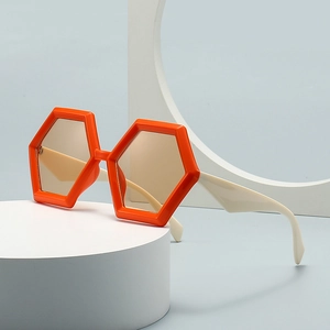 Occhiali da sole retrò con montatura arancione e aste crema in un set di studio geometrico