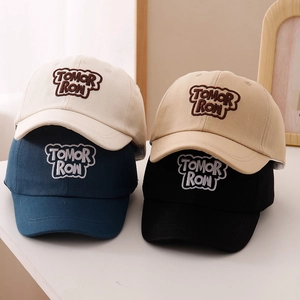 Detail view showing four colors of embroidered Tomorrow cotton baseball caps for kids