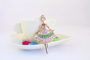 Close-up of golden ballerina keychain with vibrant red, green, and white rhinestones