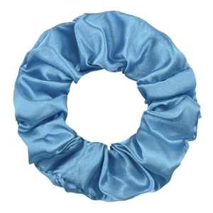 Detail of blue satin scrunchie with silky texture and elegant fabric folds