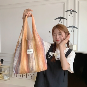 Détail du sac cabas en tricot rayé montrant la texture et l'étiquette LOVE SOZAKKA