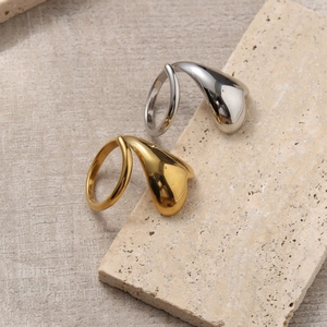 Gold and silver intertwined heart open rings in polished stainless steel on stone base