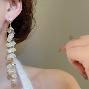 Orecchini a nappa argentati con perle di cristallo mostrati sulla modella