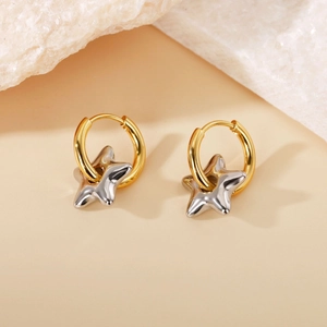 Detailed close-up of two-tone star drop earrings with silver stars and gold hoops