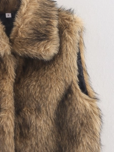 Detailopname van de zachte imitatiebonttextuur en de halslijn van het bruine vest