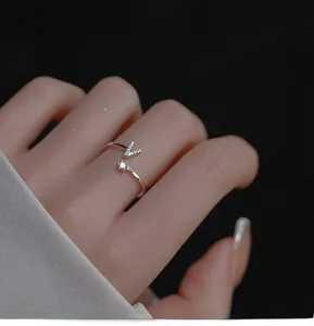 Macro detail of silver adjustable open ring featuring V-shape pave and single round crystal