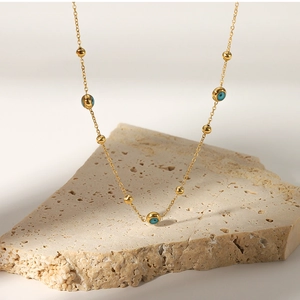 Detail of 18K gold-plated stainless steel necklace with turquoise beads and blue eye charm