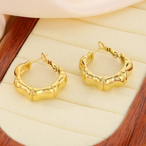 Close-up of 18K gold-plated bamboo joint hoop earrings on a beige velvet jewelry tray