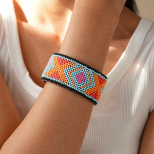 Close-up of colorful geometric beaded wide bracelet on wrist for a boho ethnic style