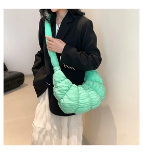 Detail of mint green dumpling bag showing pleated texture and half-moon silhouette