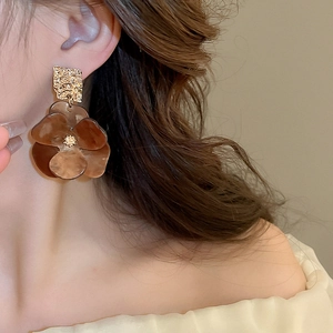 Detail of vintage amber acrylic flower earrings with textured gold metal squares