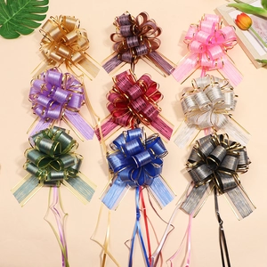 Flat lay of 9 colorful textured mesh pull bows with gold trim for gift wrapping