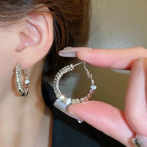 Boucles d'oreilles créoles en argent serties de zircons présentées en gros plan