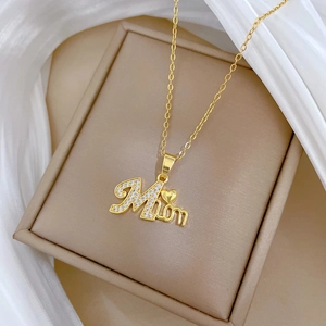 Close-up of golden MAMA heart pendant with crystals in a luxury jewelry gift box