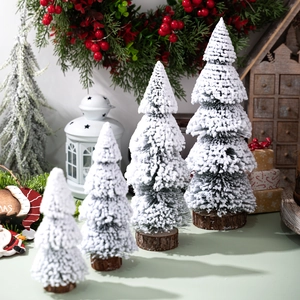 Mini frosted Christmas trees with wooden bases in a cozy holiday home setting