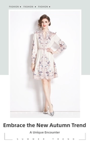 Dettaglio del ricamo floreale su abito beige chiaro con cuciture delicate