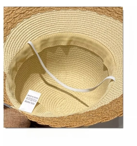 Detail view of straw sun hat interior with sweatband, elastic strap and 100% paper tag