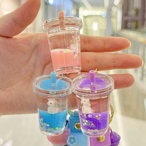 Close-up of liquid unicorn keychain charms with floating stars in pink, blue, and purple