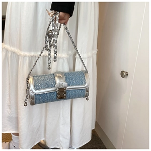 Detail of light blue tweed cylinder bag with silver chain strap and metallic buckle
