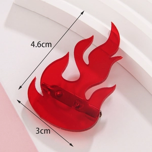 Detail view of red acrylic flame brooch with size markings measuring 4.6cm by 3.0cm