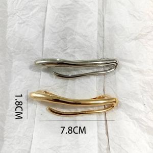 Detailed view of wave-shaped hair clips in gold and silver showing 7.8cm dimensions